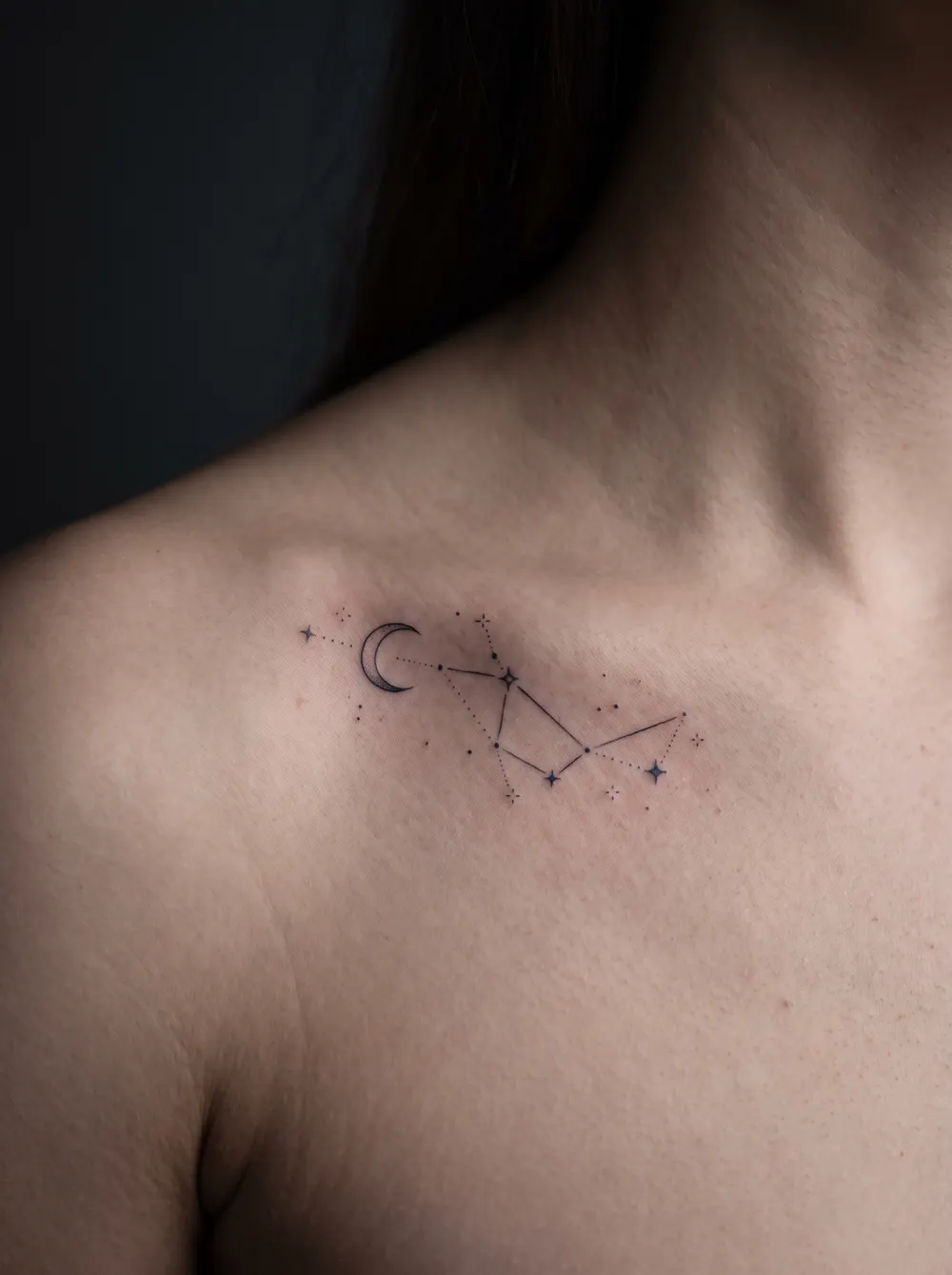 Fine-line constellation with a crescent moon on the collarbone