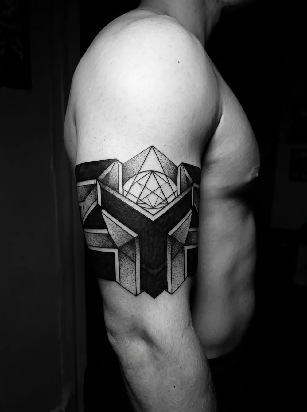 Geometric band on the upper arm — bold, but note how much bare skin the facets leave