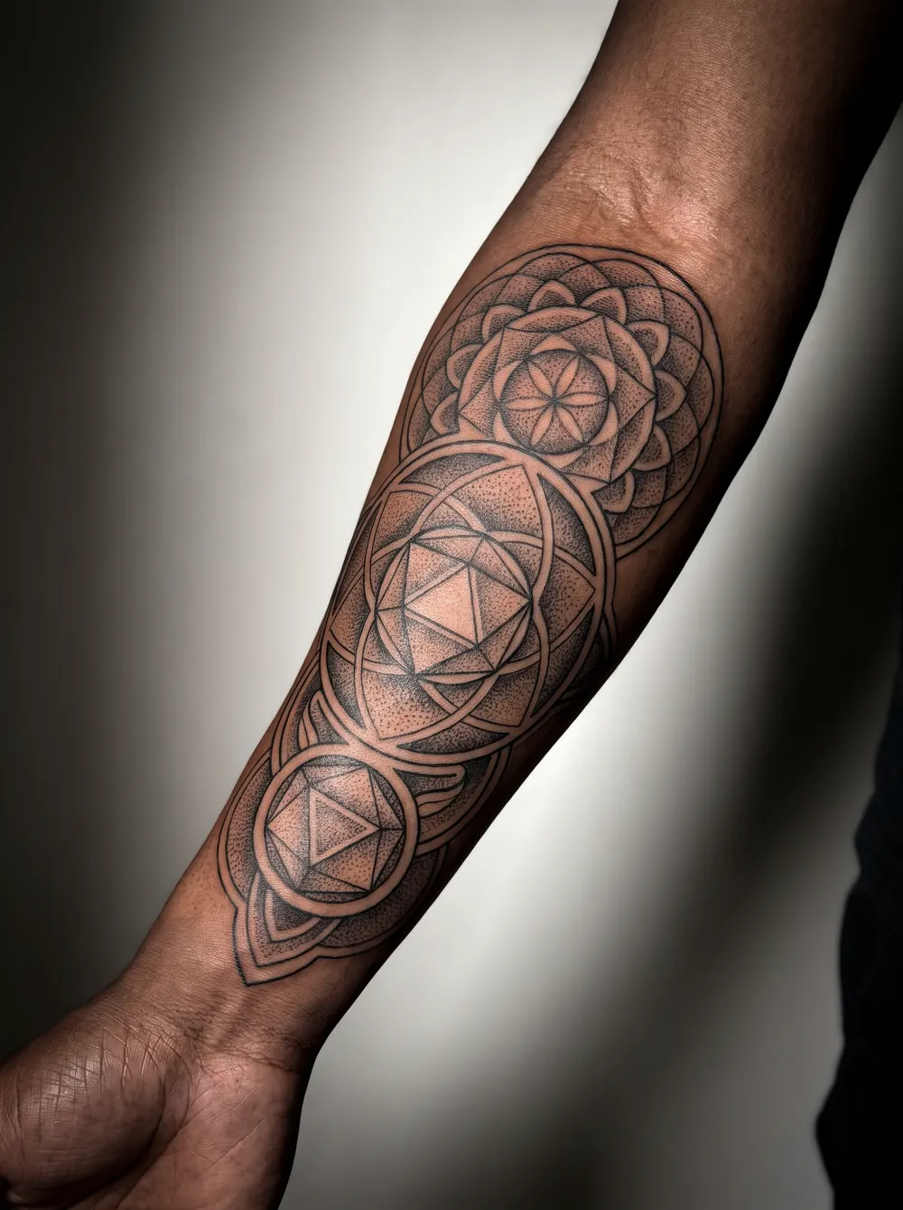 Geometric dotwork running down the forearm