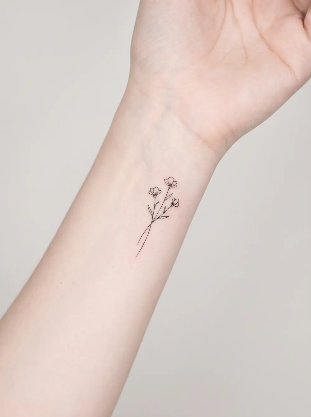 Minimalist fine-line wildflowers on the wrist